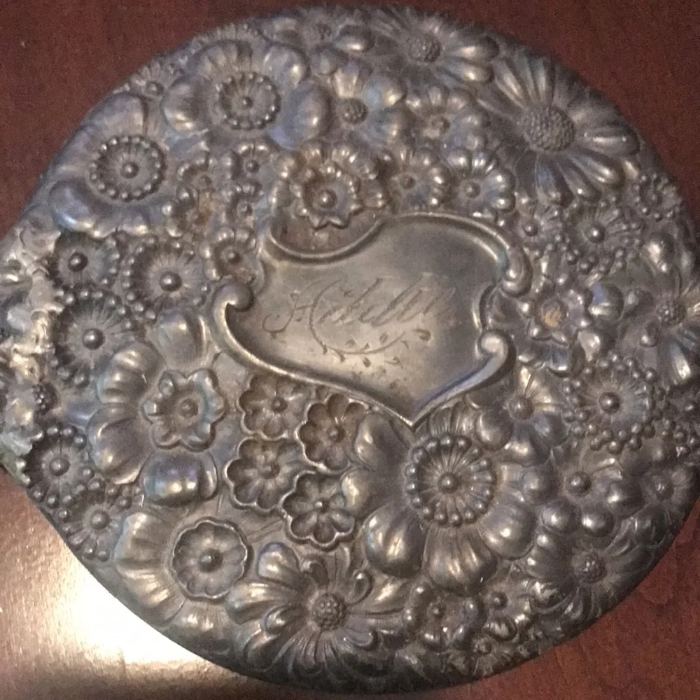 Vintage silver hand held mirror with raised flowers